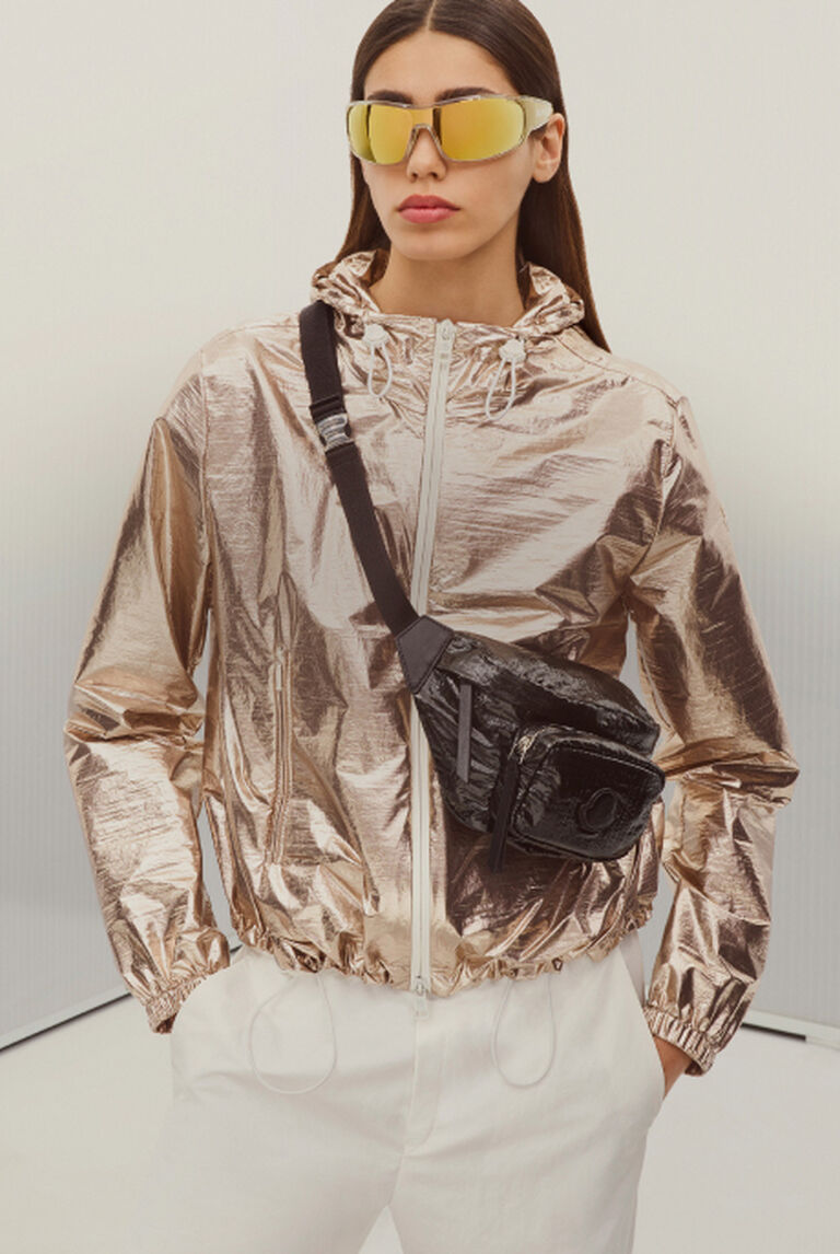A woman wearing a golden rain jacket and mirrored glasses