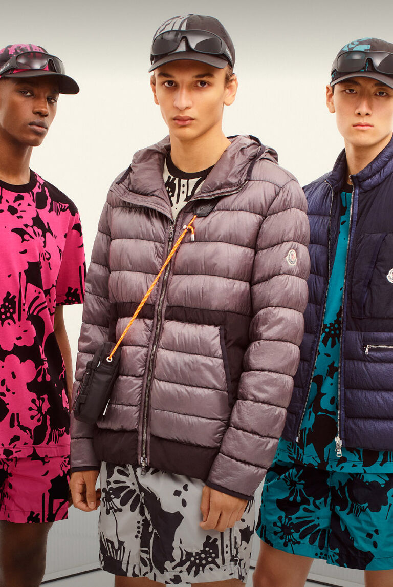 Three men wearing Moncler jackets with visor hats